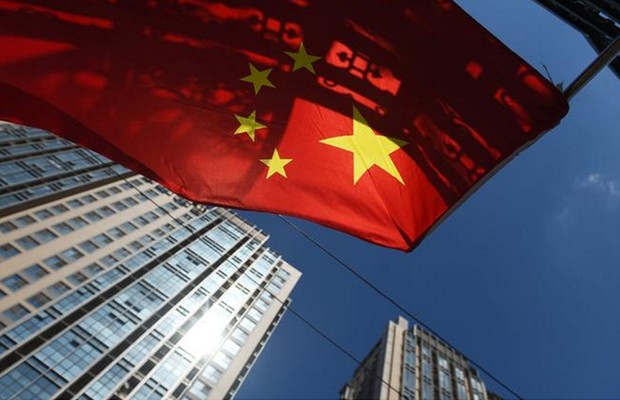 Bandeira chinesa tremula perto de um conjunto de apartamentos em Pequim ; PIB da China ; produção industrial da China ; economia da China ;  (Foto: Greg Baker/AFP/Getty Images)