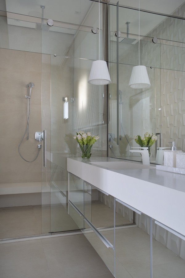 portas espelhadas no gabinete do banheiro ampliam o espaço e a luz natural 