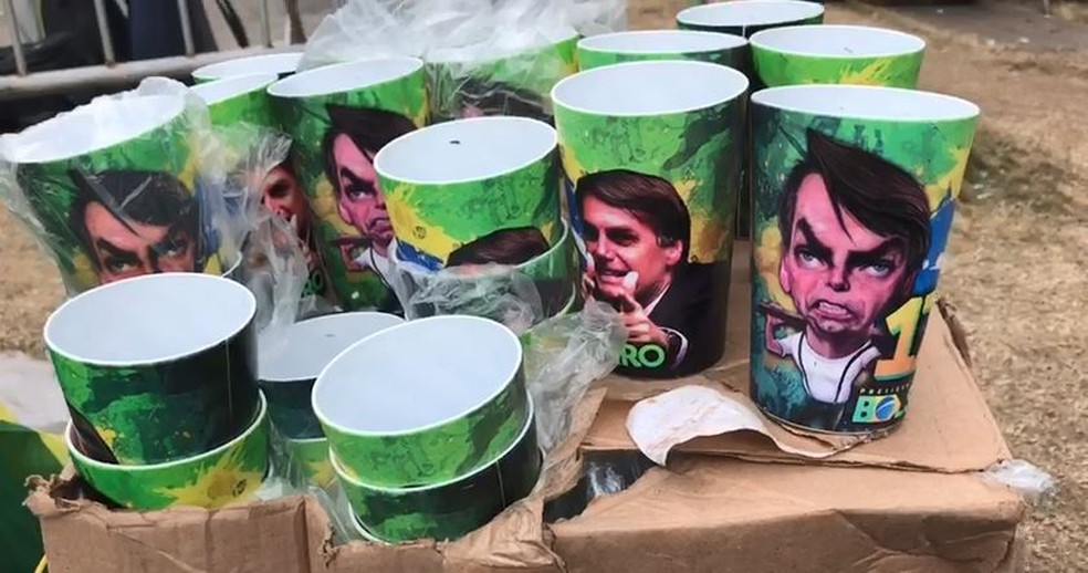 Copos com imagens de Bolsonaro são vendidos a R$ 15 em frente ao condomínio do político — Foto: Patricia Teixeira/G1