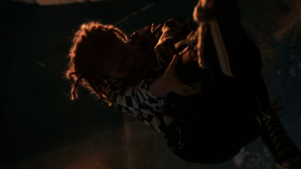 Joy (Lara Tremouroux) até vai tentar sustentar o corpo sobre a corda, que não vai resistir — Foto: Globo