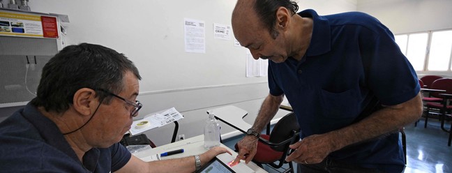 Eleitor faz a verificação biométrica antes de votar em uma seção em Brasília — Foto: Evaristo Sá / AFP