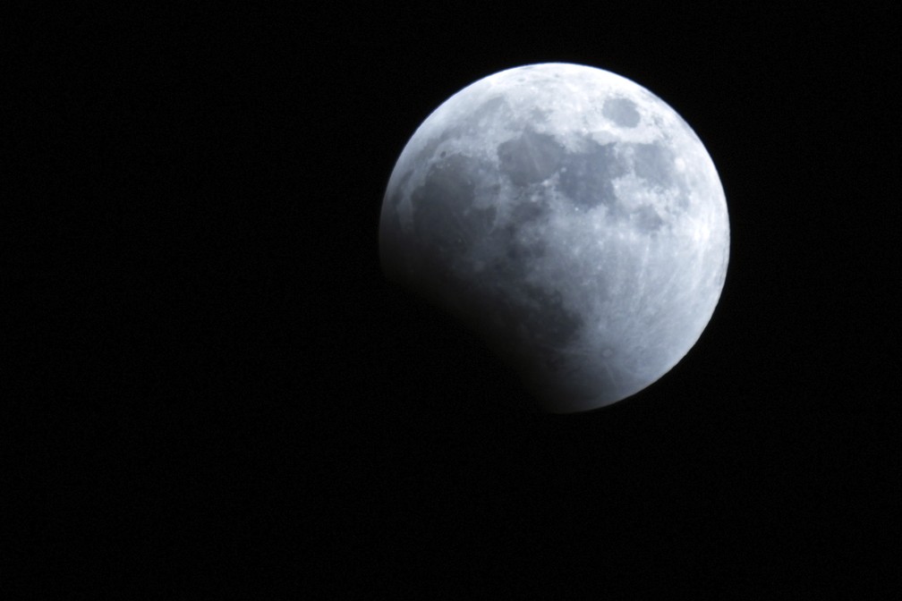 Sombra da Terra começa a cobrir a lua durante um eclipse lunar nesta terça-feira, 8 de novembro de 2022, em Yokohama, perto de Tóquio. — Foto: AP Photo/Eugene Hoshiko