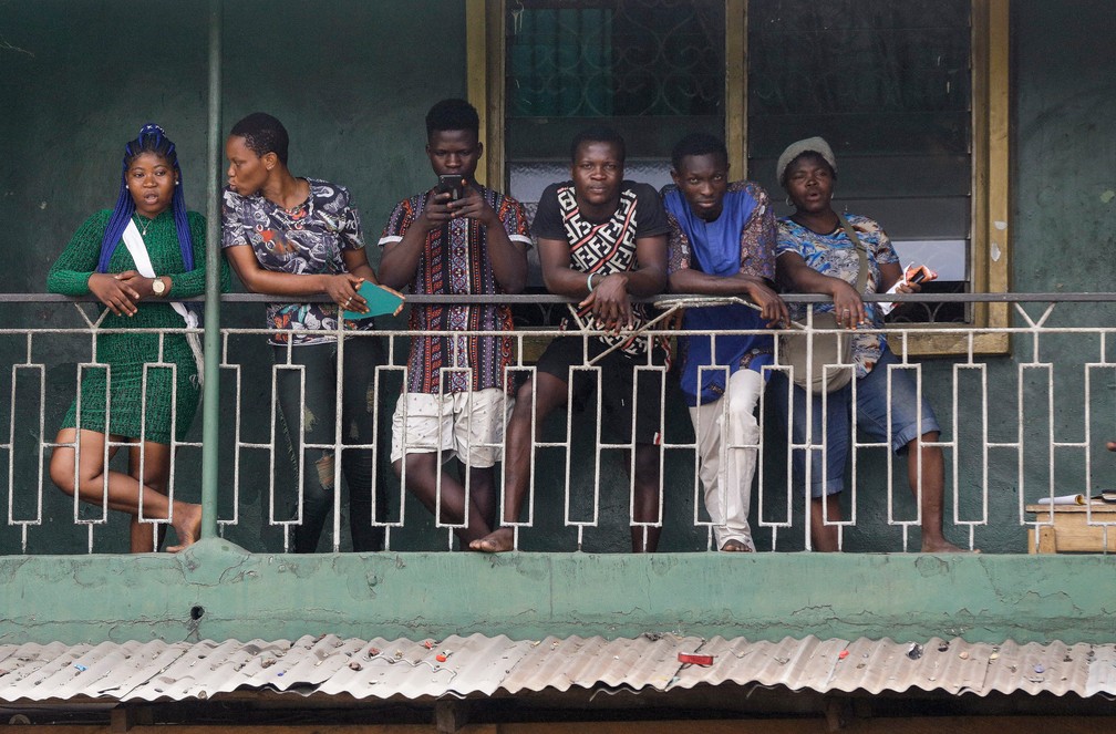 Moradores de um prédio olham da varanda em Lagos, na Nigéria, durante isolamento para evitar a propagação do novo coronavírus — Foto: Sunday Alamba/AP