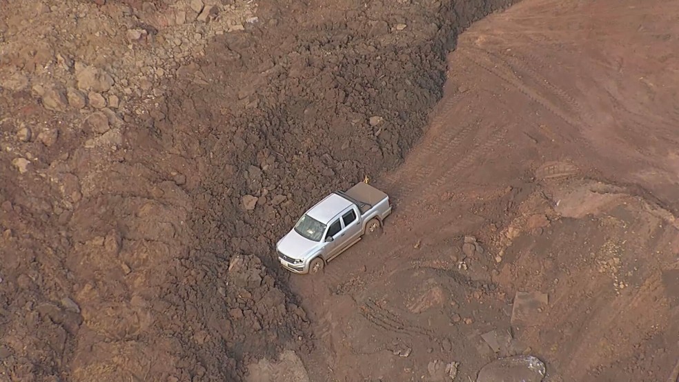 Um carro foi soterrado após deslizamento de terra em Sarzedo — Foto: TV Globo