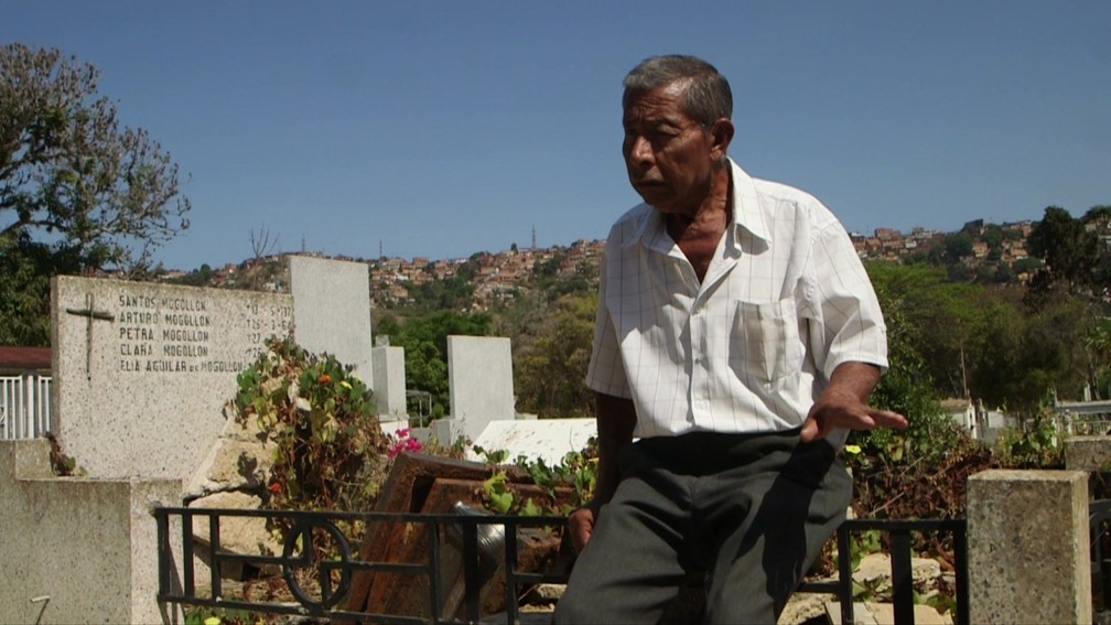 Eladio Batisda diz que vigia o túmulo da mulher em cemitério da Venezuela para evitar ação de vândalos — Foto: BBC