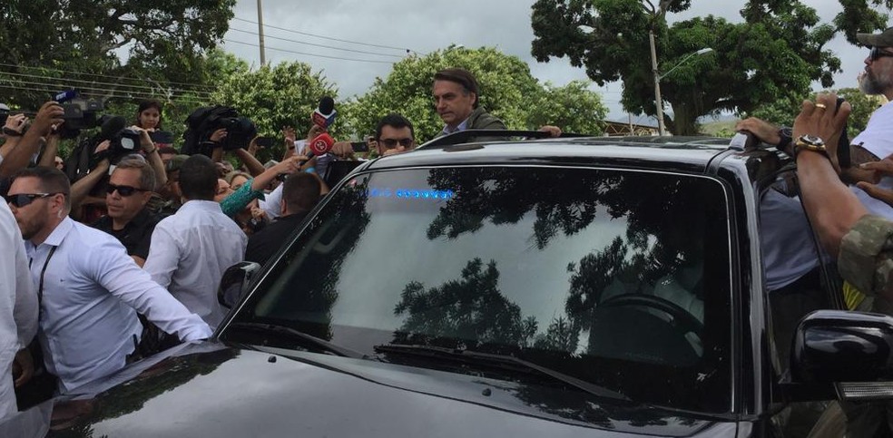 Bolsonaro coloca parte do corpo para fora da janela do carro para acenar para eleitores ao deixar escola em que votou na zona oeste do Rio â€” Foto: Cristina Boeckel, G1