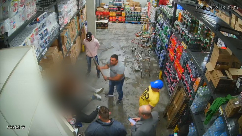 Homem usa pedaço de madeira para agredir as vítimas em supermercado do RS. — Foto: Reprodução/RBS TV
