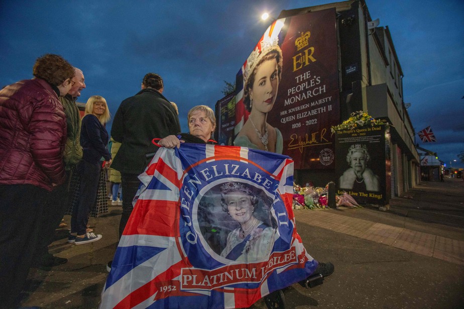 Mulher com bandeira do partido unionista durante homenagens à rainha Elizabeth II em Belfast, capital da Irlanda do Norte