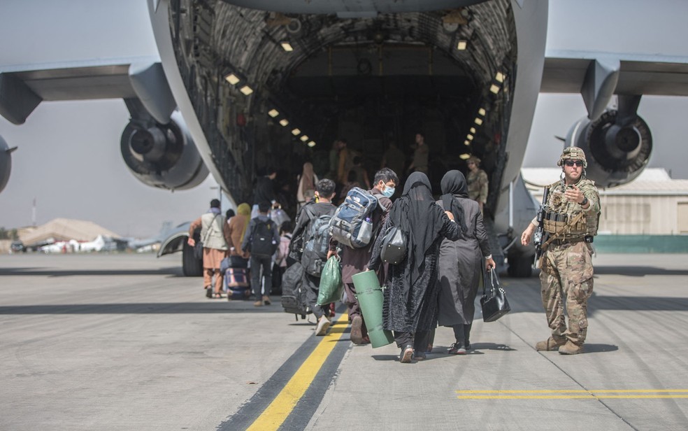 Famílias afegãs embarcam em Boeing C-17 da Força Aerea dos EUA no aeroporto internacional Hamid Karzai, em Cabul, no Afeganistão, na segunda-feira (23) — Foto: Samuel Ruiz/US Marine Corps/AFP