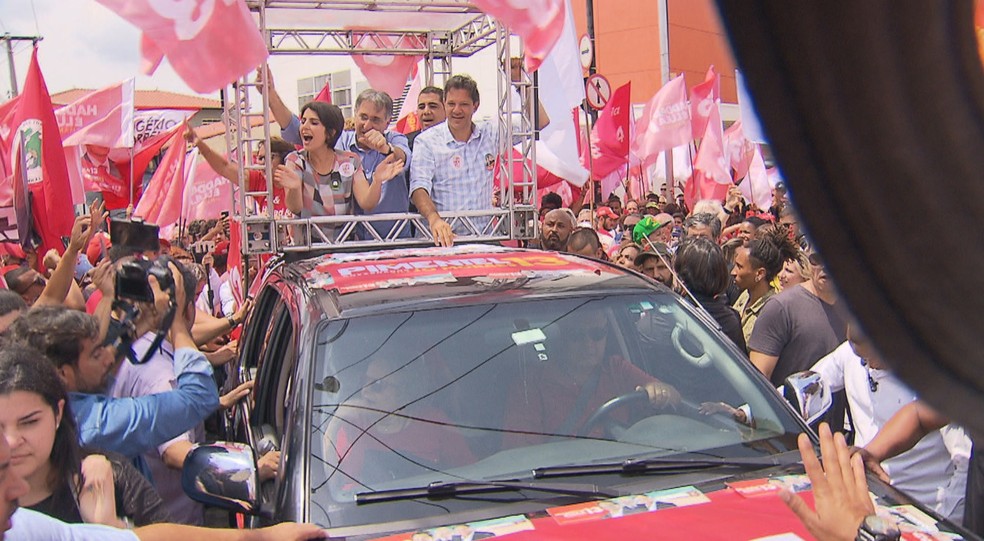 Ao lado da vice na sua chapa, Manuela D'Ávila, Fernando Haddad (à direita) faz campanha em cima de caminhonete — Foto: Reprodução / TV Globo