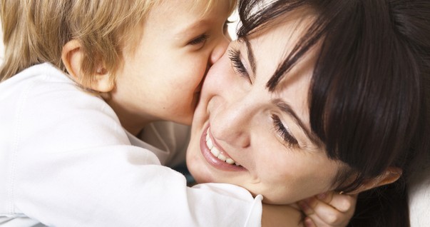 Mulher feliz abraçando criança (Foto: Shutterstock)