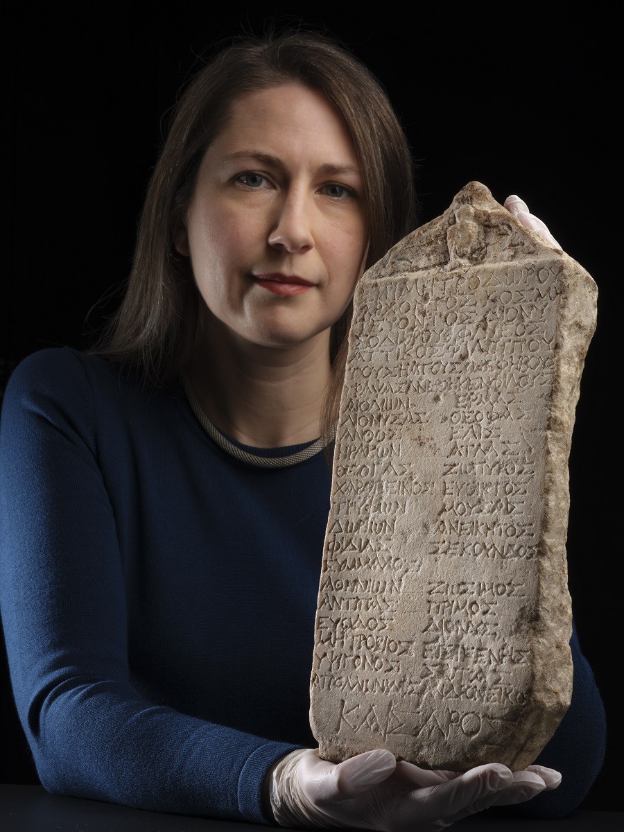 Margaret Maitland, curadora dos Museus Nacionais da Escócia, posa com a tábua, que data dos primeiros dias do domínio romano sobre a Grécia (Foto: National Museums Scotland)