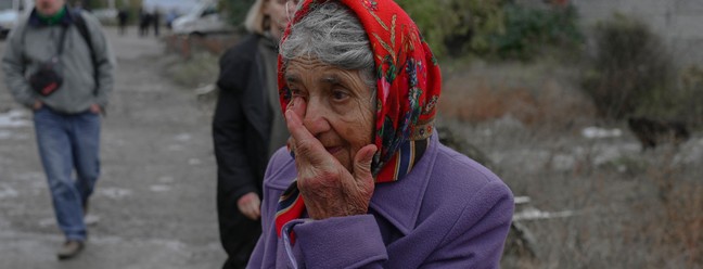 Mulher chora em uma rua após um ataque de foguete em Mykolaiv, Ucrânia — Foto: BULENT KILIC/AFP