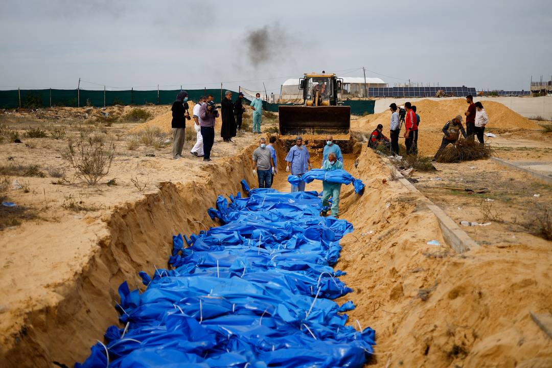 Corpos dos palestinos mortos em ataques e incêndios israelenses são enterrados em uma vala comum, em Khan Younis, sul da Faixa de Gaza, em 22 de novembro de 2023