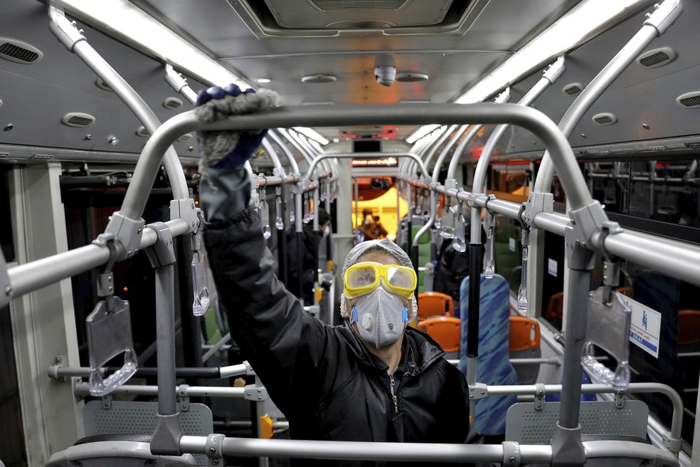 Funcionário desinfeta ônibus em Teerã, no Irã, nesta quarta-feira (26): país passa por crise com novos casos do novo coronavírus — Foto: Ebrahim Noroozi/AP Photo