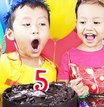 Criança assoprando vela de bolo de aniversário (Foto: Shutterstock)