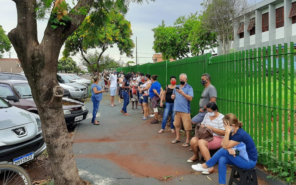 Moradores formam fila na porta da escola Jardim das Rosas em Serrana, SP, para cadastro da vacinação — Foto: Vinícius Alves/G1