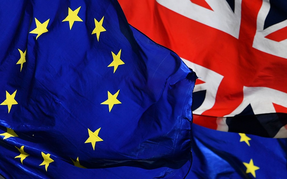 Bandeiras da União Europeia e do Reino Unido são vistas do lado de fora do Parlamento britânico no dia 14 de março — Foto: Ben Stansall/AFP