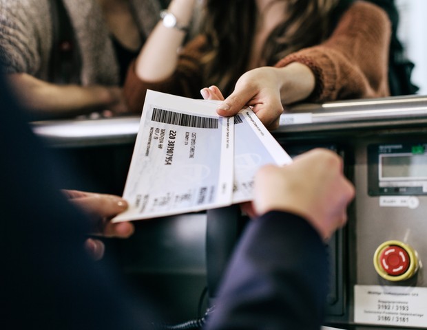 Travellers getting their boarding passes at airline check-in counter (Foto: Getty Images)