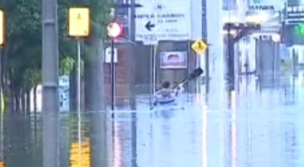 Morador usa caiaque para percorrer rua alagada após chuva em SC — Foto: Reprodução/NSC TV