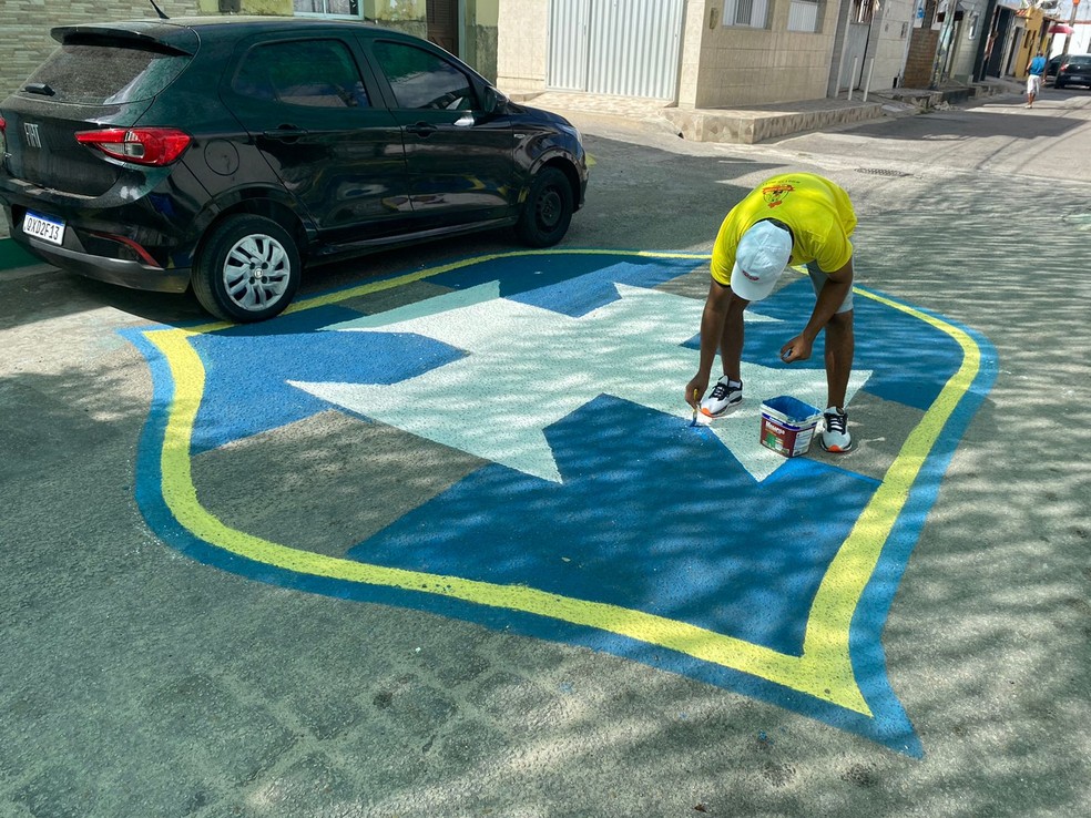 Homem pinta rua do bairro das Rocas, Zona Leste de Natal, com símbolo da CBF.  — Foto: Pedro Trindade/Inter TV Cabugi