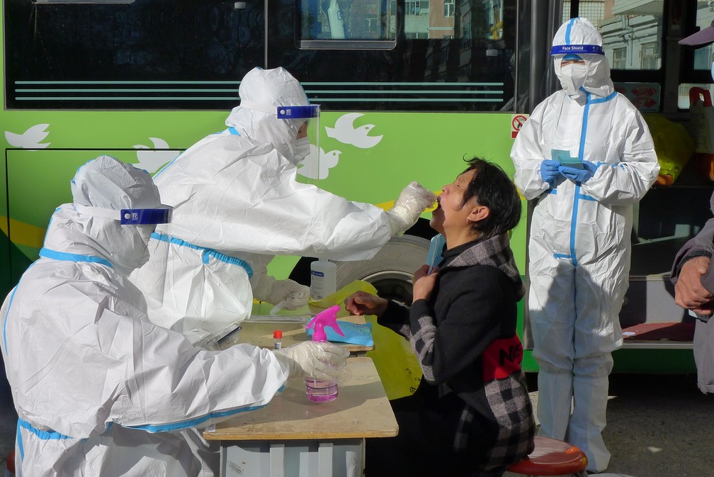 Profissionais de saúde coletam amostra para teste de Covid-19 em morador do distrito de Aihui, na cidade de Heihe, após novos casos serem registrados na província de Heilongjiang, na China, em 31 de outubro de 2021 — Foto: China Daily via Reuters