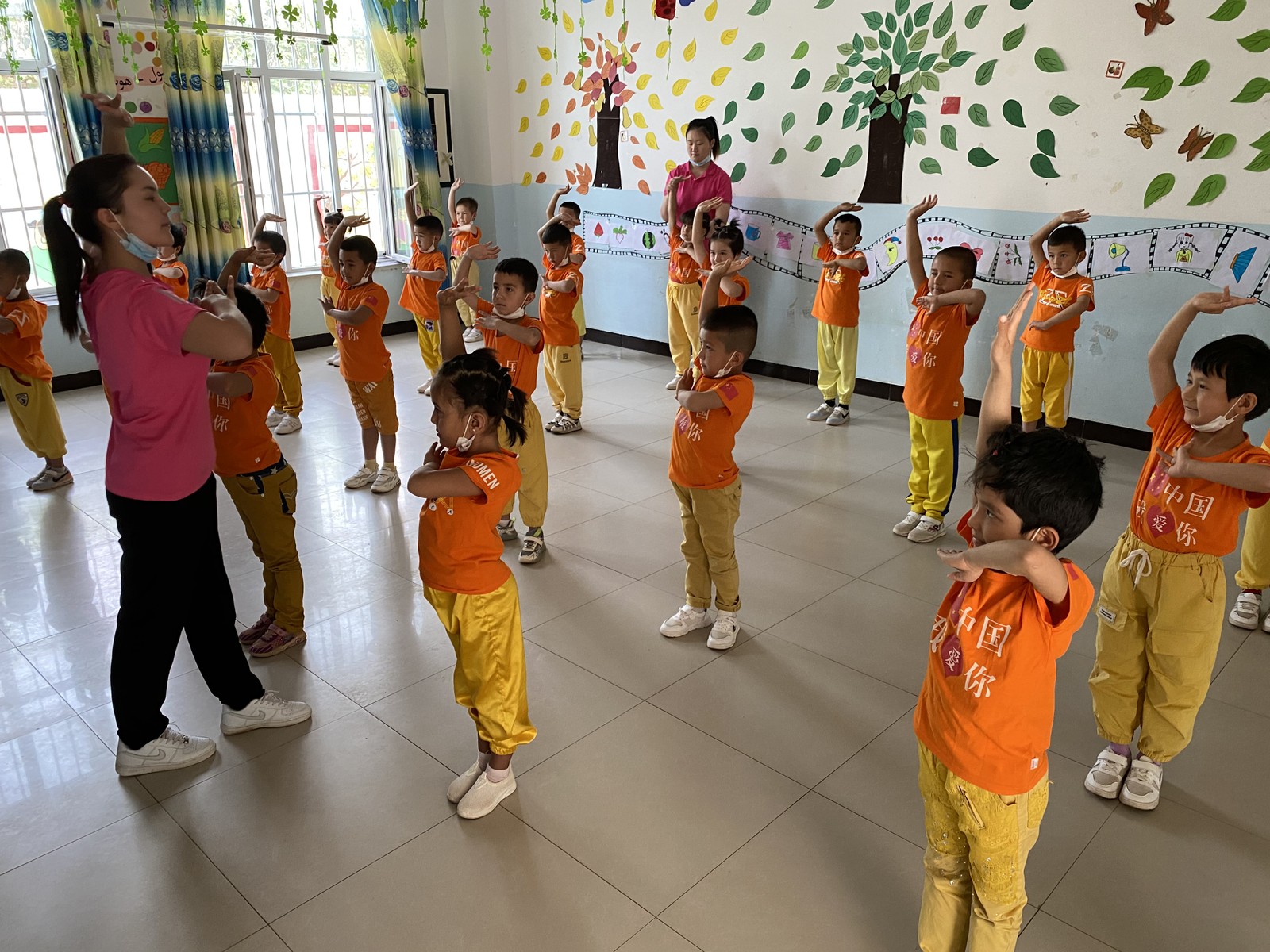 Crianças uigures são mostradas como exemplo de harmonia étnica em escolas-modelo. Nas camisetas, a frase "Eu amo a China"Agência O Globo