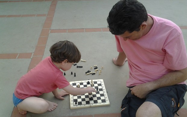 Infância. Sênior Ensinando Seu Neto a Jogar Xadrez. Criança