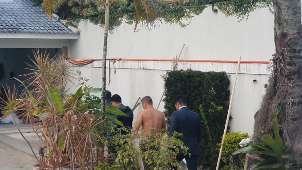 Marlon Márcio Mendes Alvarenga (sem camisa) recebe os agentes em sua casa na Barra — Foto: Divulgação