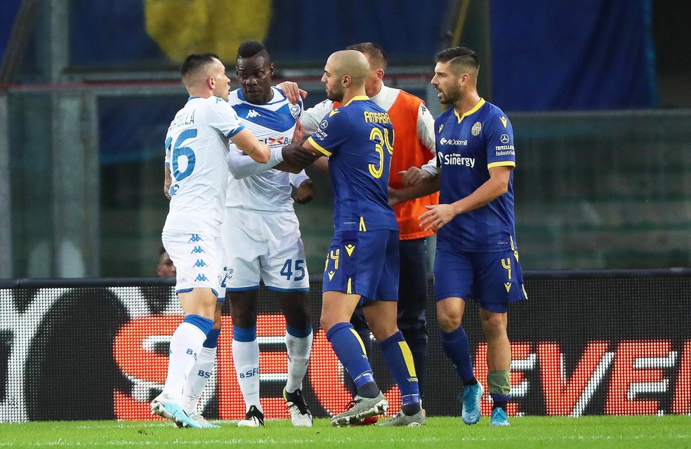 Jogadores do Brescia e do Hellas Verona tentam convencer Balotelli a ficar em campo depois de reação a insultos racistas — Foto:  EFE/EPA/SIMONE VENEZIA