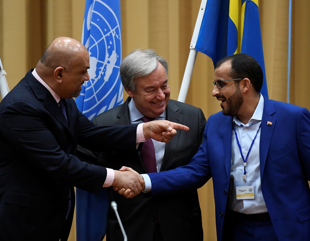 Representante da delegaÃ§Ã£o houthi, Mohammed Abdul-Salam (Ã  direita), e ministro das RelaÃ§Ãµes Exteriores do IÃªmen, Khaled al-Yaman (E), se cumprimentam prÃ³ximo ao secretÃ¡rio-geral da ONU AntÃ³nio Guterres â€” Foto: TT News Agency/Pontus Lundahl via Reuters