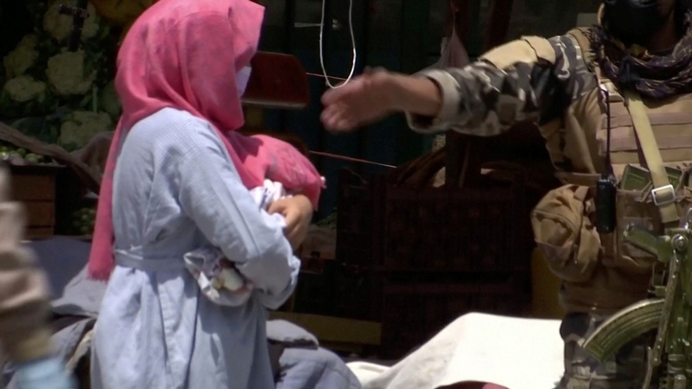 Mulher leva bebê de hospital atacado em Cabul, no Afeganistão, em 11 de maio — Foto: Reuters via Reuters TV