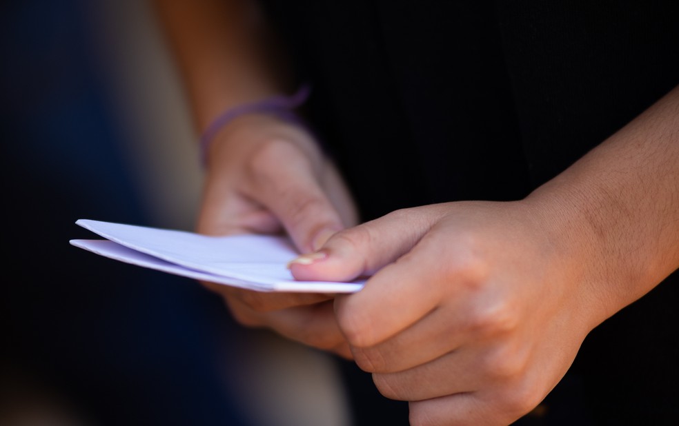 Enem 2021: Estudante segura cartão de prova antes de entrar para sala da avaliação — Foto: Érico Andrade/g1