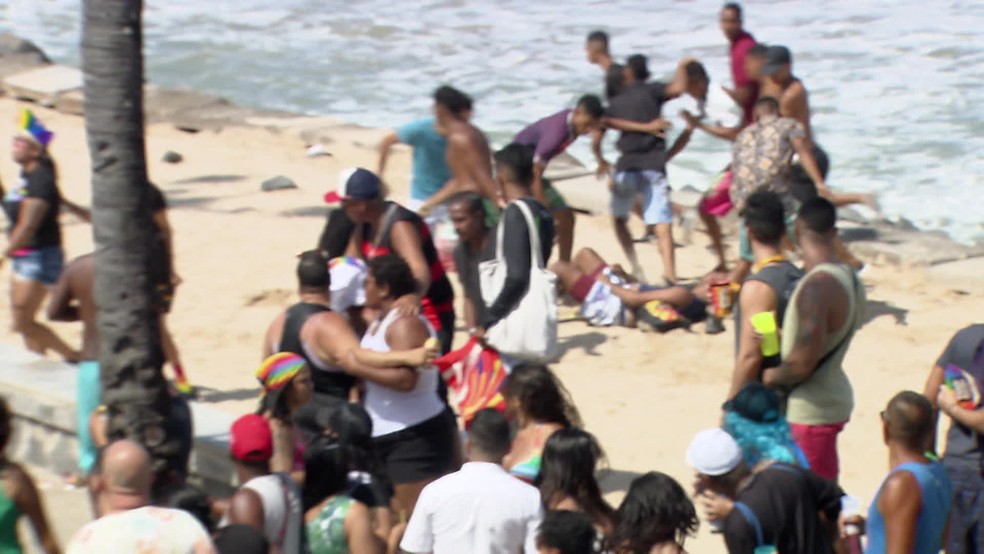 Imagens mostram oito pessoas dando chutes em um homem na orla de Boa Viagem durante a Parada da Diversidade — Foto: Reprodução/TV Globo
