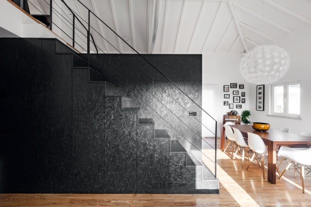 Pintado de preto, o OSB trouxe uma atmosfera contemporânea à área. O volume serve como suporte para a escada e armários (Foto: João Morgado / Divulgação)