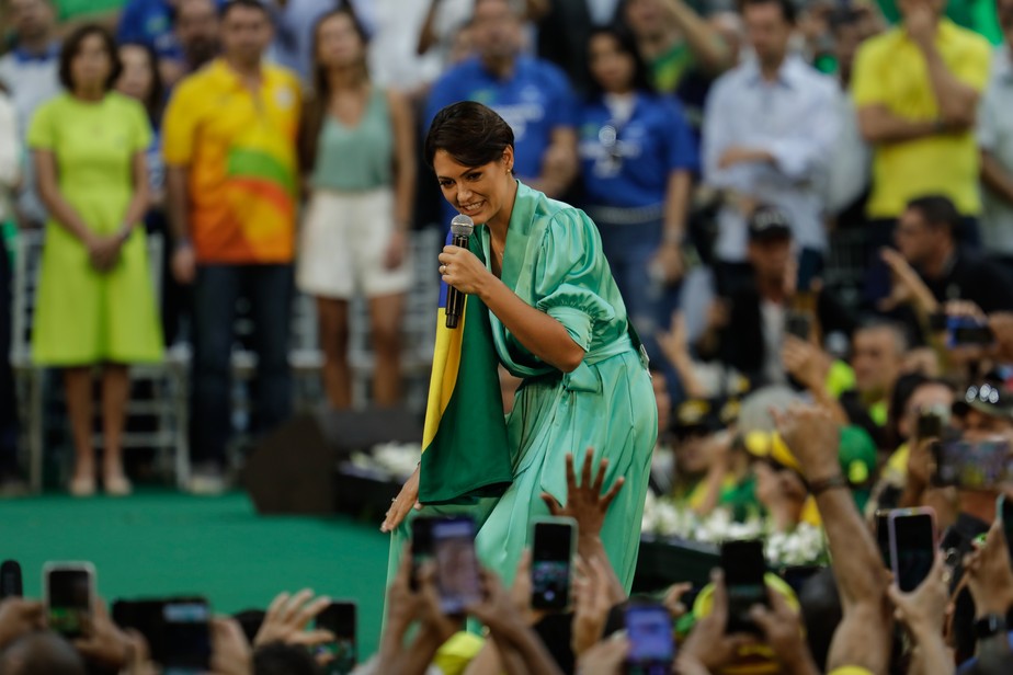 Michelle Bolsonaro carrega a bandeira do Brasil na convenção do PL, no Maracanãzinho