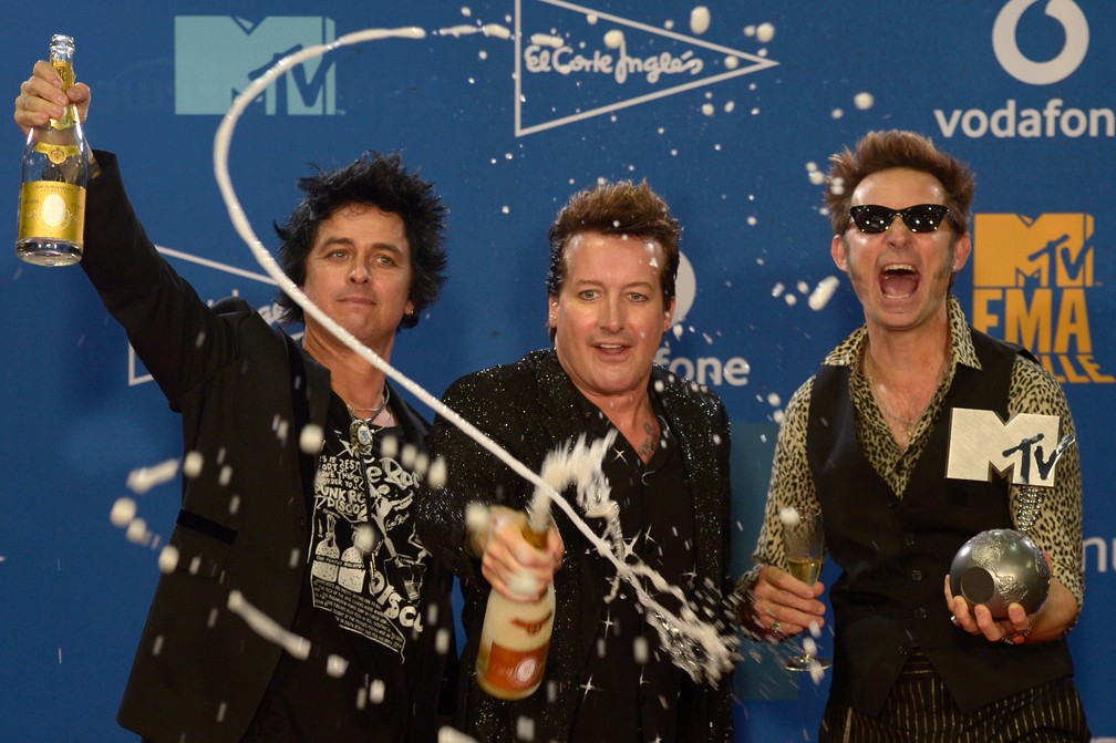 Membros da banda Green Day comemoram MTV EMA de Melhor Artista de Rock neste domingo (3), em Sevilha — Foto: Cristina Quicler/AFP