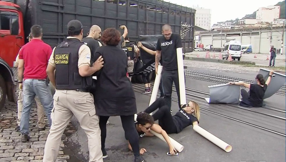 Ativistas chegaram a cair no chão durante protesto no Porto de Santos, SP (Foto: Reprodução/TV Tribuna)