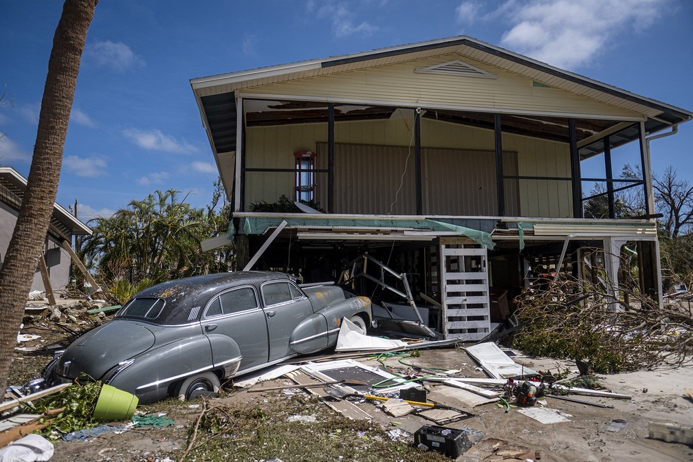 Carro clássico é visto diante de uma casa em bairro atingido pelo furacão Ian em Fort Myers, Flórida — Foto: Ricardo Arduengo/AFP