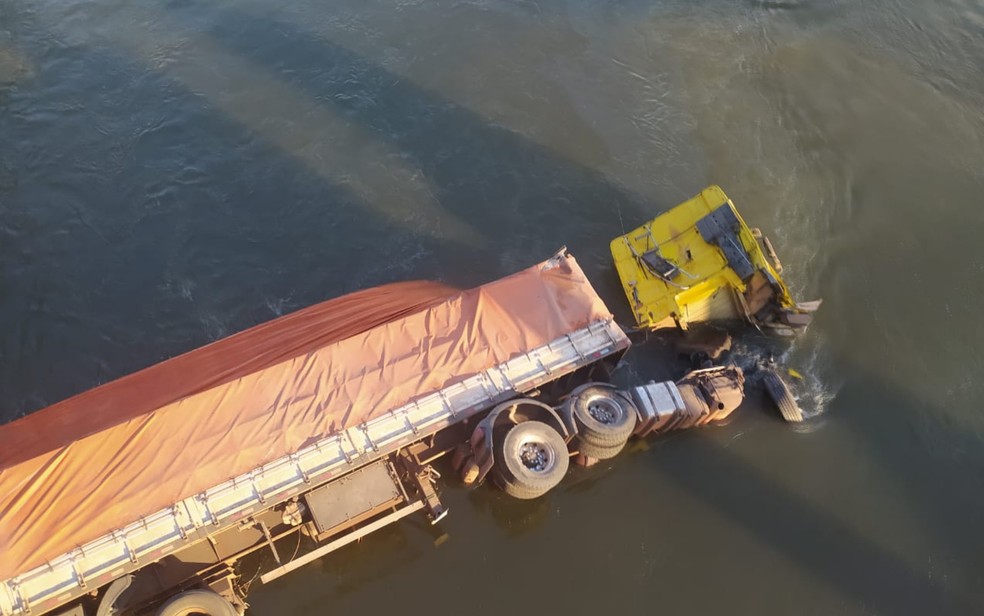 Motorista joga caminhão de ponte ao tentar evitar acidente, cai em rio e é resgatado por pescadores, em Itumbiara — Foto: Reprodução/TV Anhanguera