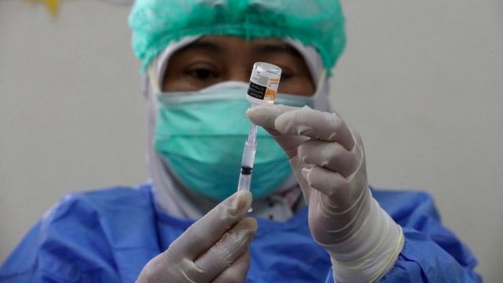 Profissional de saúde prepara vacina.  — Foto: EPA via BBC