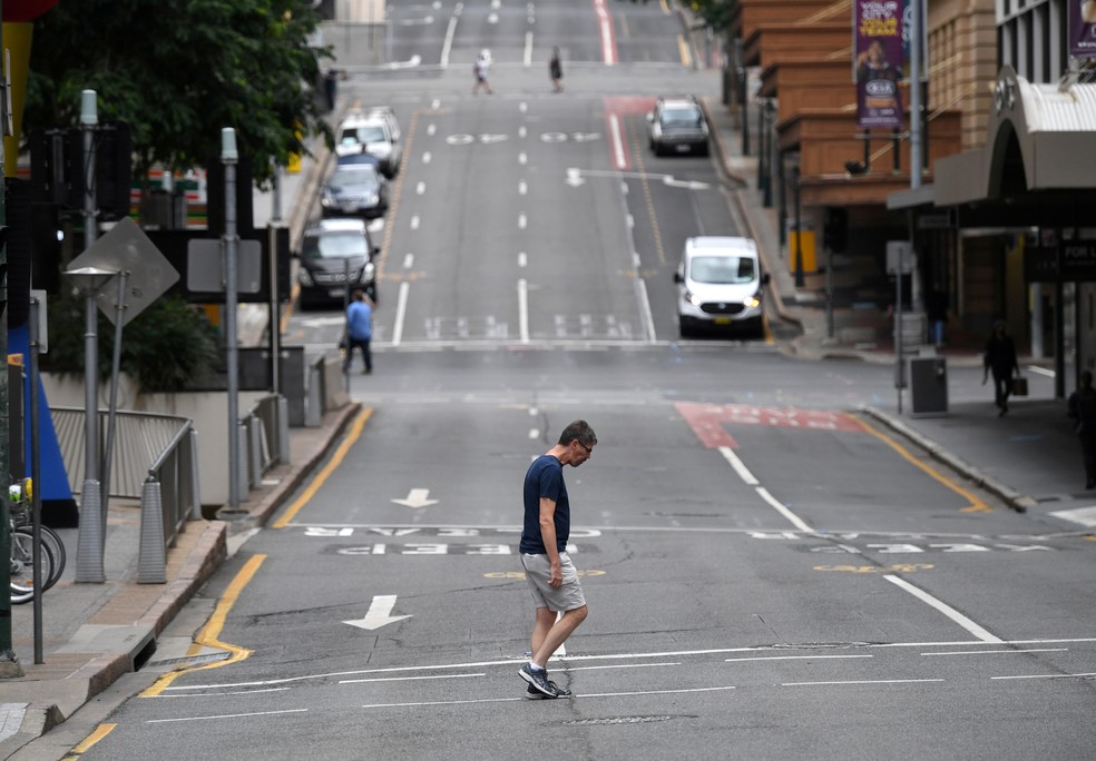 Homem caminha em rua vazia de Brisbane, na Austrália, em 30 de março, após imposição de lockdown na cidade — Foto: AAP Image/Darren England via Reuters