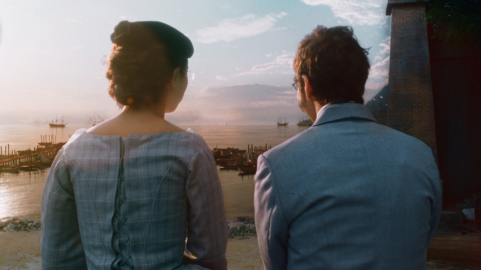 Dolores (Daphne Bozaski) e Nélio (João Pedro Zappa) observam o mar juntos em 'Nos Tempos do Imperador' — Foto: Globo