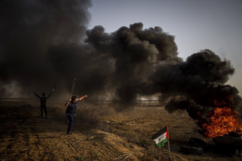 Palestino lança pedra contra soldados israelenses em protesto contra as operações de Israel na Cisjordânia, em 25 de outubro de 2022. — Foto: Fatima Shbair/ AP