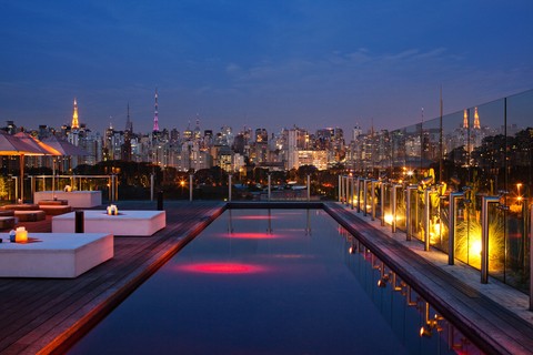 A piscina avermelhada do Hotel Unique, em São Paulo, oferece uma vista panorâmica da cidade