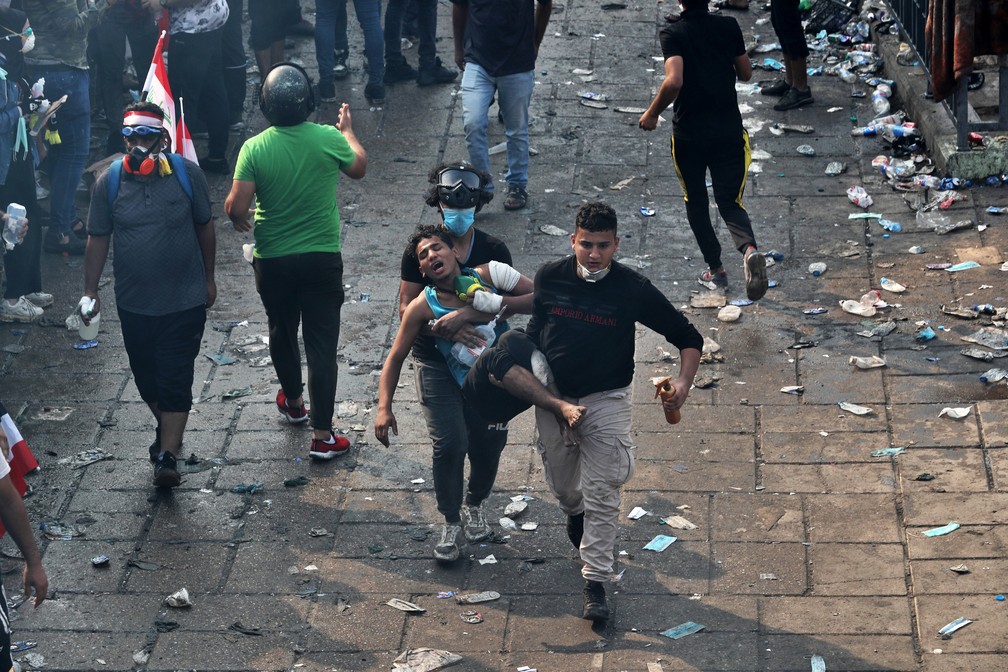 Manifestante ferido é levado a hospital durante protesto em Bagdá, no Iraque, nesta terça-feira (29) — Foto: Khalid Mohammed/AP Photo