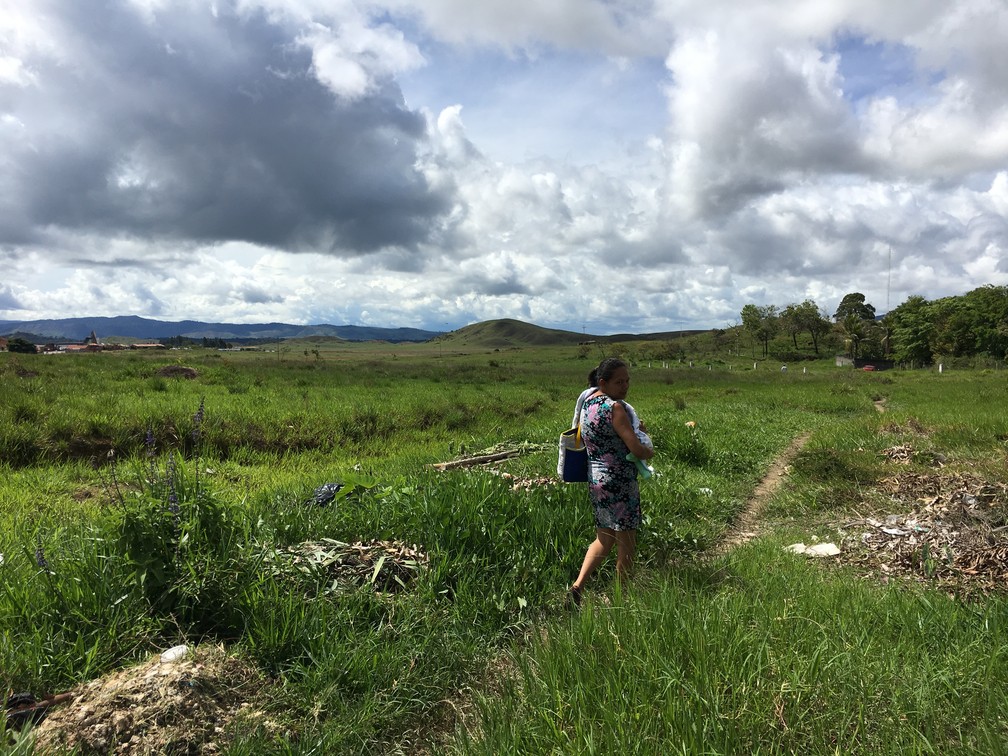 Venezuelana com bebê de colo atravessa fronteira com o país por rota clandestina: 'ele [bebê] tem um mês" (Foto: Emily Costa/G1 RR)
