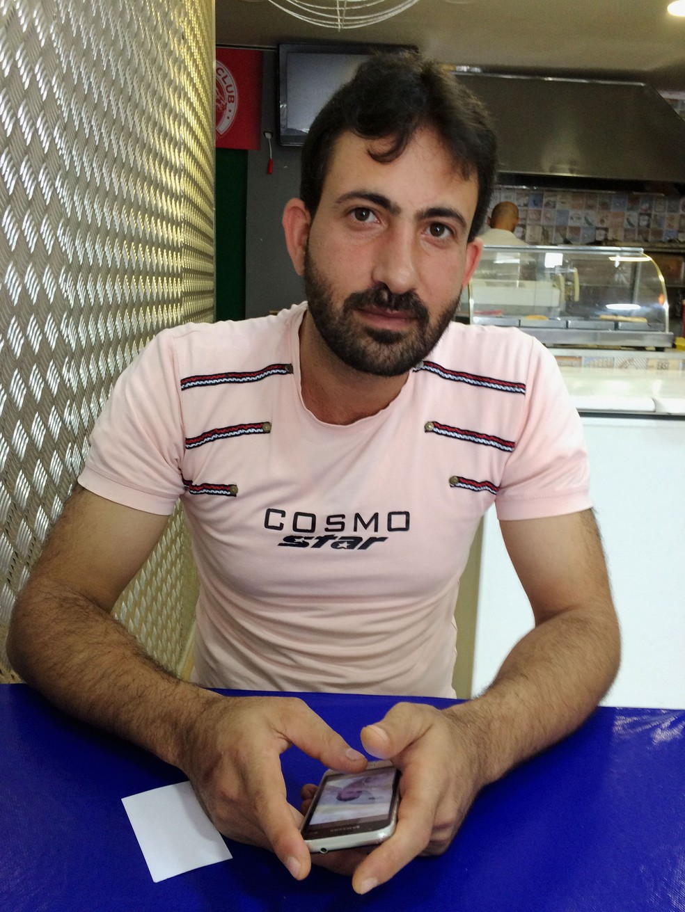Mohamad Algohorani se comunica por Whatsapp com os amigos e parentes que estão em Guta (Foto: Flávia Mantovani/G1)