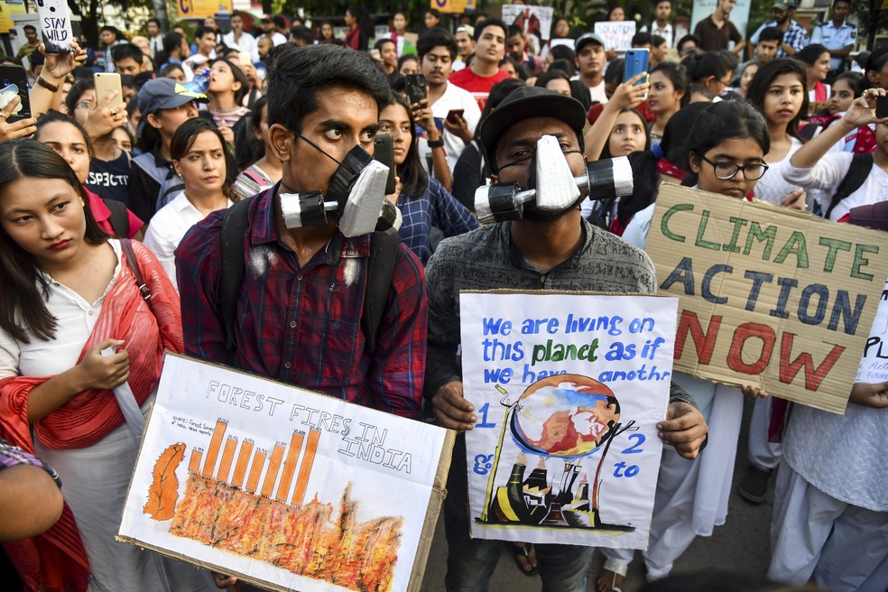Greve pelo Clima: Na Índia, manifestantes saíram às ruas de Guwahati empunhando cartazes e usando máscaras de oxigênio para alertar sobre os riscos da poluição ambiental e do aquecimento global. — Foto: Biju Boro/AFP