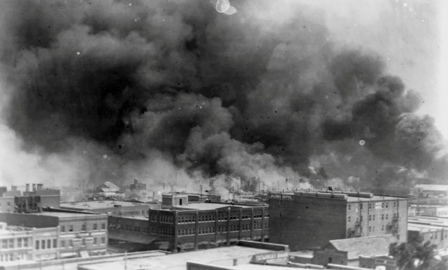 Fumaça de casas de famílias negras incendiadas no Massacre de Tulsa, em 1921